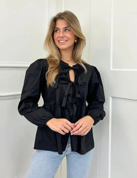 Blusa elegante con mangas abullonadas y frente con lazo para un estilo sin esfuerzo